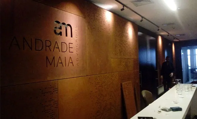 Parede de aço corten com logotipo recortado, iluminada